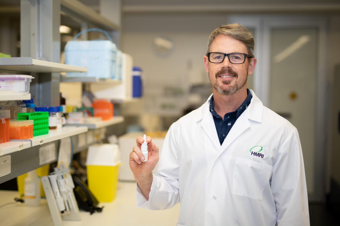 Associate Professor Nathan Bartlett holds a mockup of the immune boosting nasal spray in the HMRI labs in Newcastle, Australia.