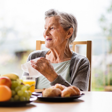 Older woman talking eating breakfast 
