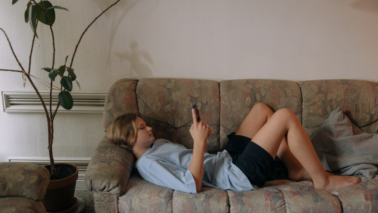 Teenage boy on phone on lounge