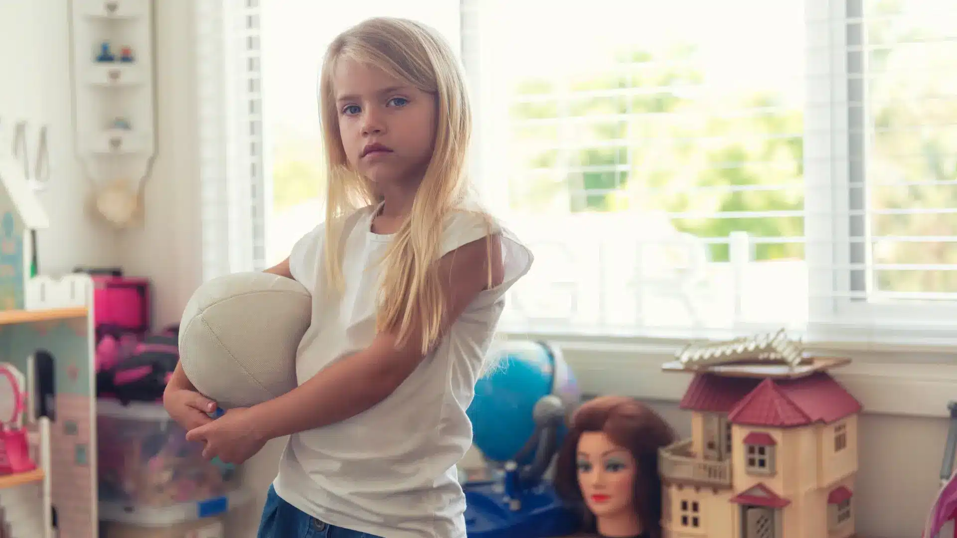 Young girl in room holding a football