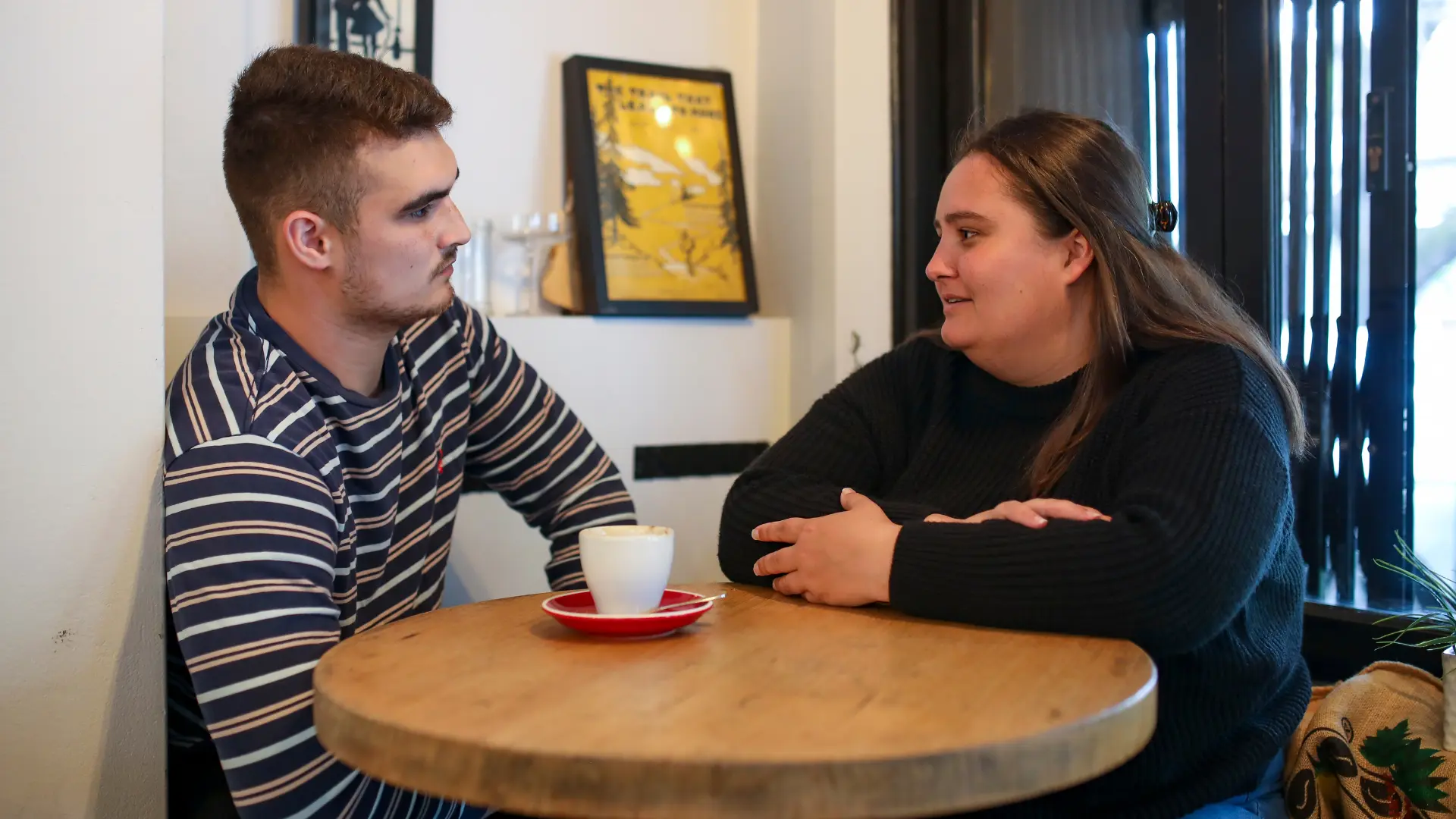 two young adults talking in cafe