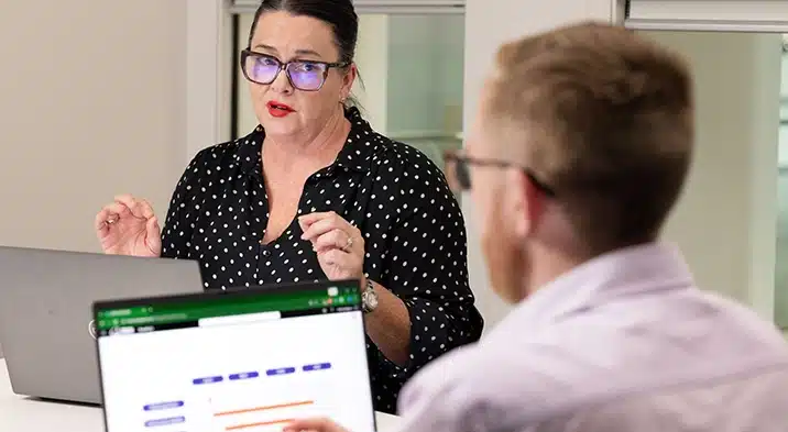 a woman in glasses talking to a man