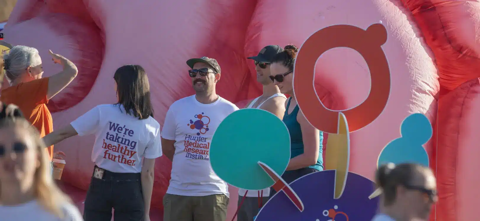 HMRI Ways to take healthy further in 2026 - HMRI staff chat with local community members in front of a large inflatable brain at 'Sip on Science' event